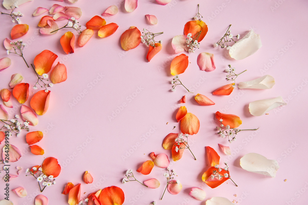 Orange, rose, and white roses petals on the pink background