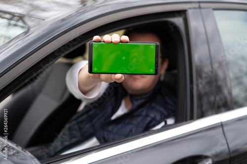 Man hold smartphone in car photo