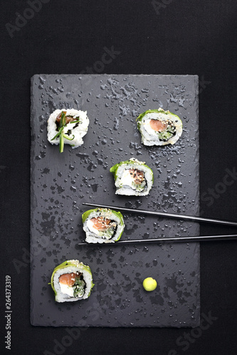 Sushi roll with salmon, cucumber, cheese, kampyo and avocado slices. photo