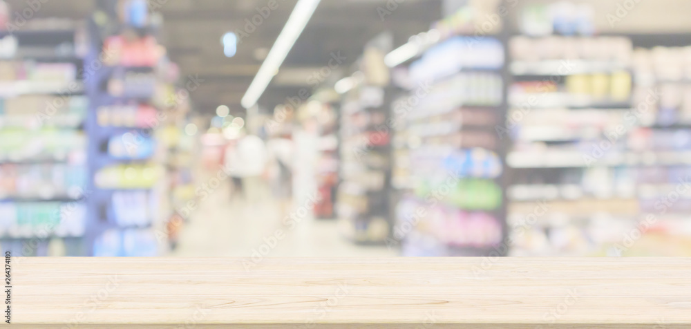 Empty wood table top with supermarket aisle with product shelves interior defocused blur background