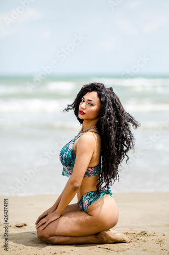 Sensual tanned sexy girl in swimsuit posing on beach
