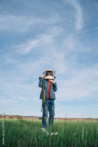 Adorable kid with helmet in the field