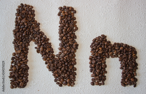 Image of roasted coffee beans shaped alphabet on a white background