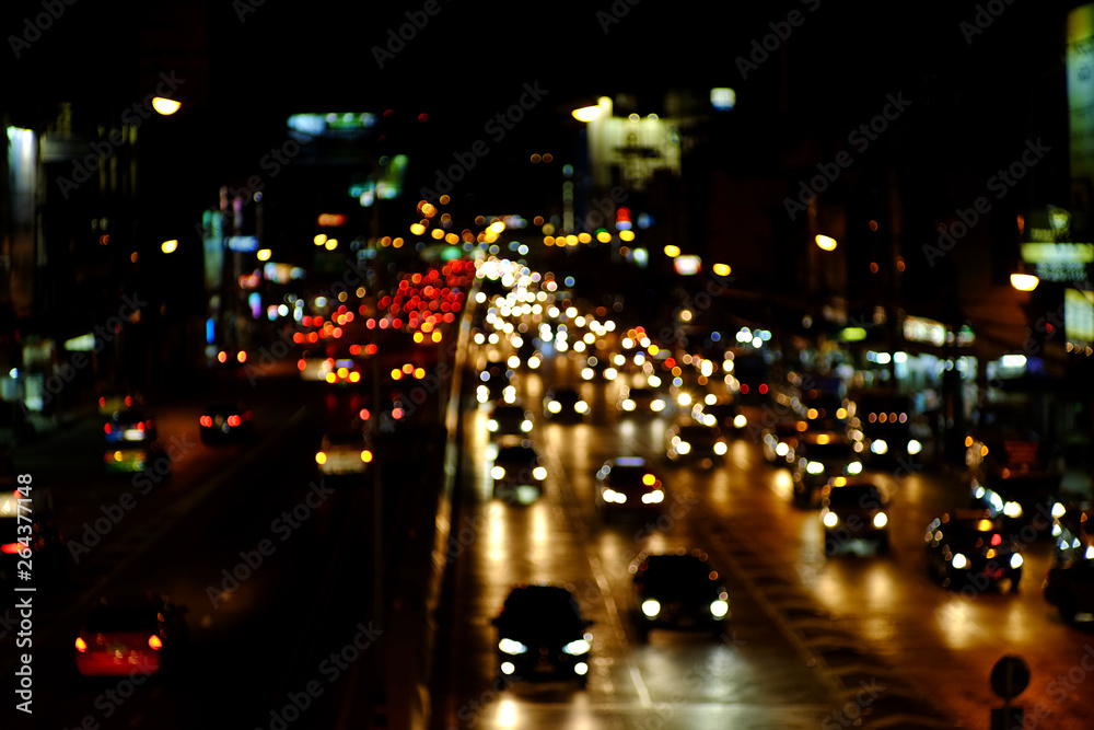 Defocused light car traffic jam of a street road at night in city with bokeh