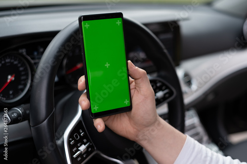 Man hold smartphone in car on dashboard background