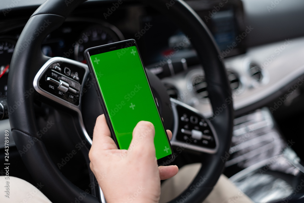 Man hold smartphone in car on dashboard background Man hold smartphone in car on dashboard background