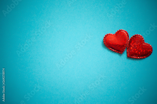 Two sparkling hearts together on blue background