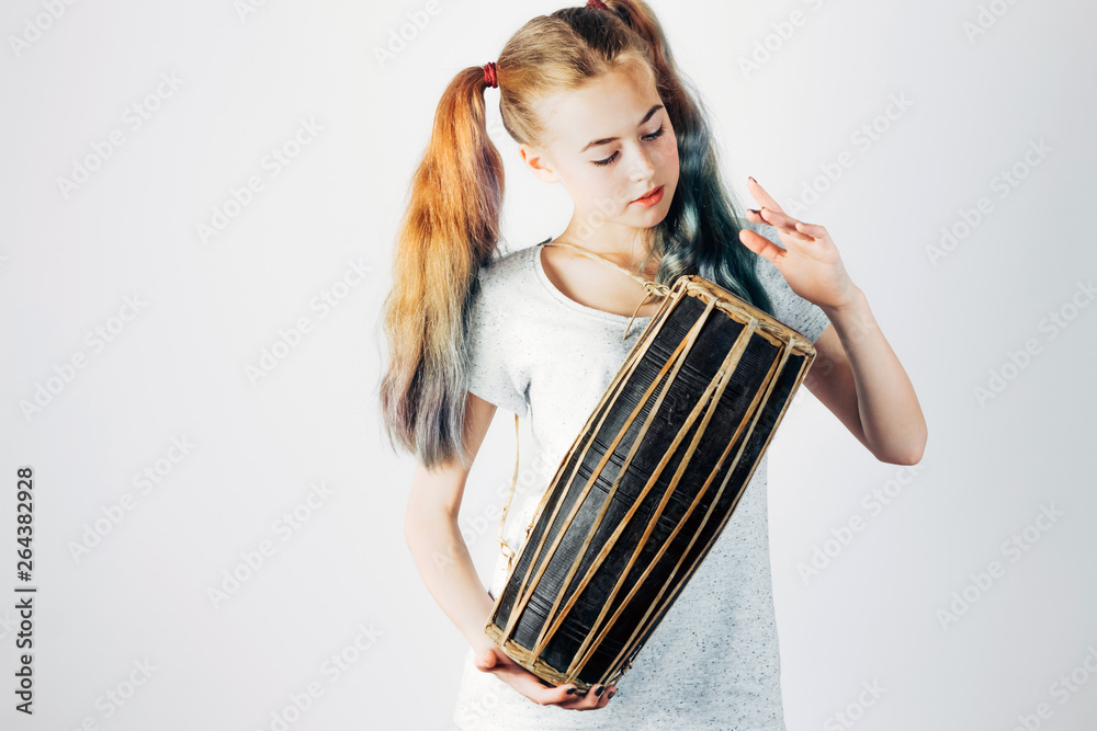 Young musician with indian drum. Beautiful girl playing the ethnic drums on  gray background. Music concept. Stock Photo | Adobe Stock