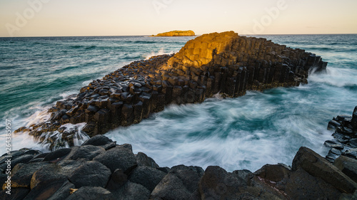 Die letzten Sonnenstrahlen treffen den fingal head causeway und die dahinter liegende Cook Island