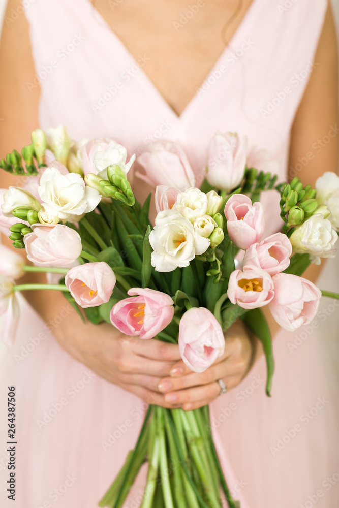 Wedding bouquet of pink tulips in bride's hands