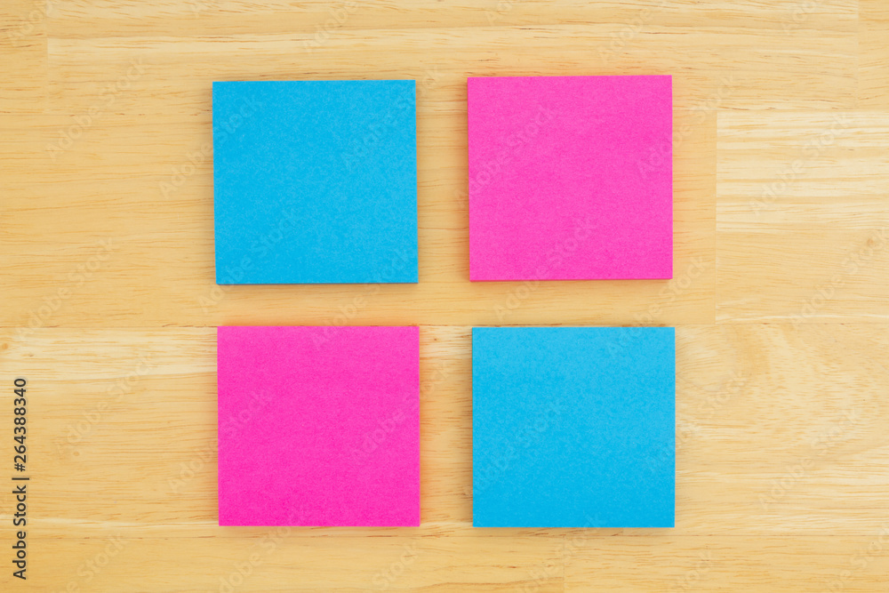Four blank sticky notes on textured desk wood background Four blank sticky notes on textured desk wood background