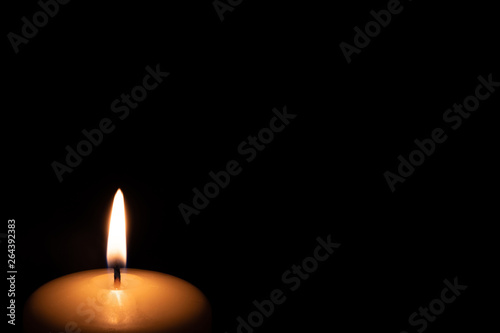 the candle burns on a black background