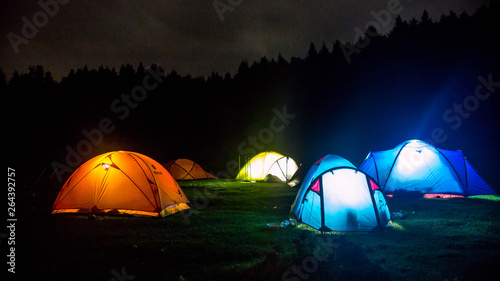 Camp tent illuminated at night under a sky