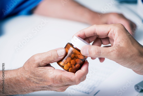 doctor giving a bottle of pills to a senior man