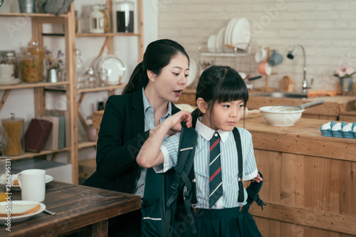 Konstfotografi young mother worker in business suit help daughter get ready for school