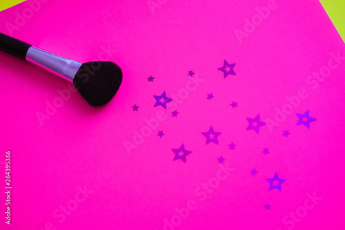 Make-up brushes on a bright pink background.