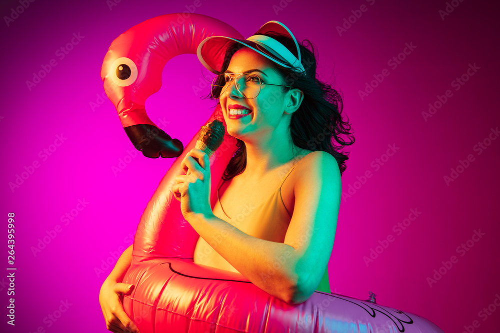Happy young woman standing and smiling against pink background Happy young woman standing and smiling against pink background