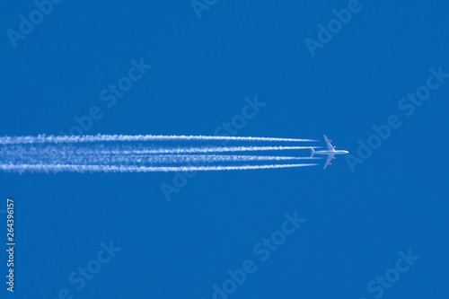 Airplanes leaving contrail trace on a clear blue sky. © aapsky