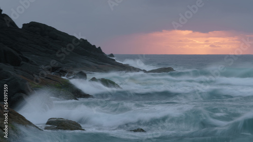 Während des Sonnenaufgangs treffen Wellen auf die steinige Küste des Hat Head National Parks © Michael
