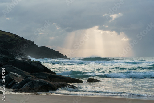 Während des Sonnenaufgangs treffen Wellen auf die steinige Küste des Hat Head National Parks