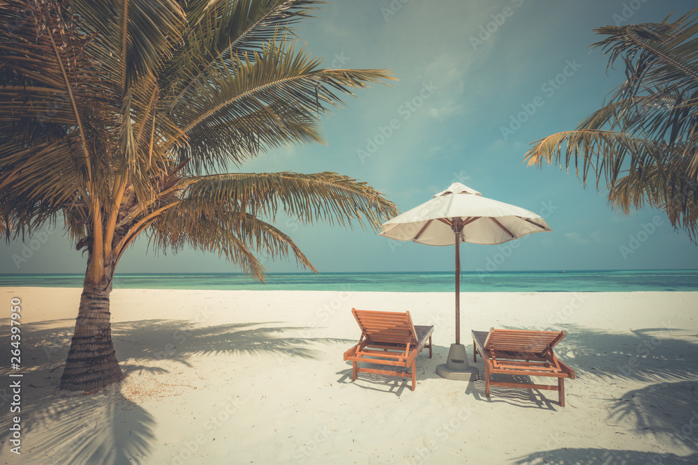 Chairs and umbrella on tropical beach. Luxury travel and vacation background