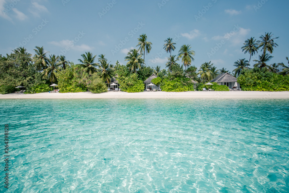 Beach landscape, exotic scenery with luxury beach villas and palms on white sand, tropical resort or hotel. Wonderful vacation and holiday scenery, soft color process - obrazy, fototapety, plakaty 