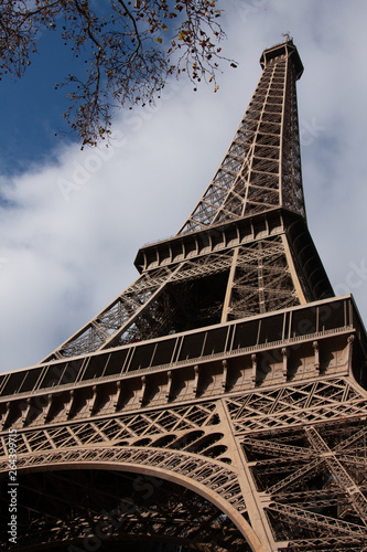 A low perspective of the Eiffel Tower with a blue sky on  an autumn day in Paris France