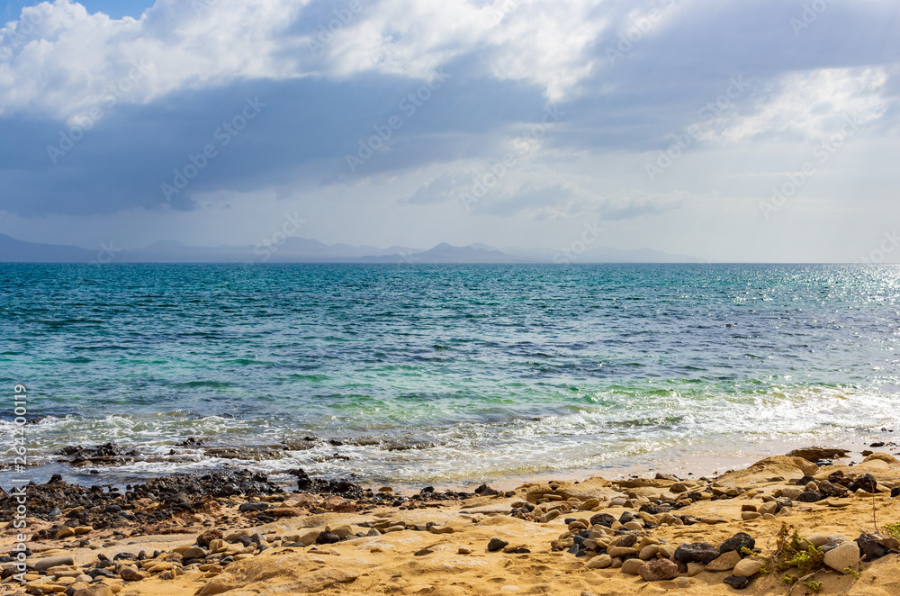Cliffs of Lanzarote seen from a beach on the island of La Graciosa