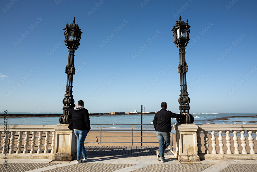 Pareja de hombres viendo el mar en Cádiz, España.