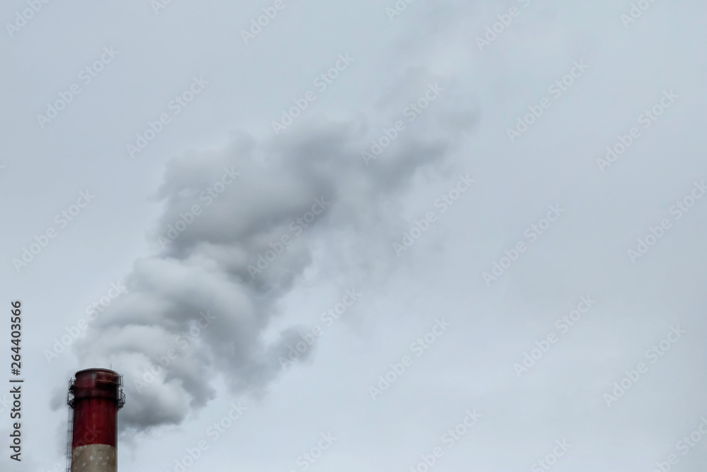 The pipe from which the smoke goes against the gray sky. The concept of air pollution, CO2, carbon dioxide gas, exhaust gases. The pipe from which the smoke goes against the gray sky. The concept of air pollution, CO2, carbon dioxide gas, exhaust gases.