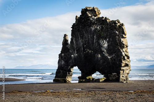 Basalt rock Hvitserkur in the form of a huge elephant on the shores of the Atlantic Ocean in northern Iceland at low tide, during low water. Wet sand and blue sky on background. Icelandic outdoor.