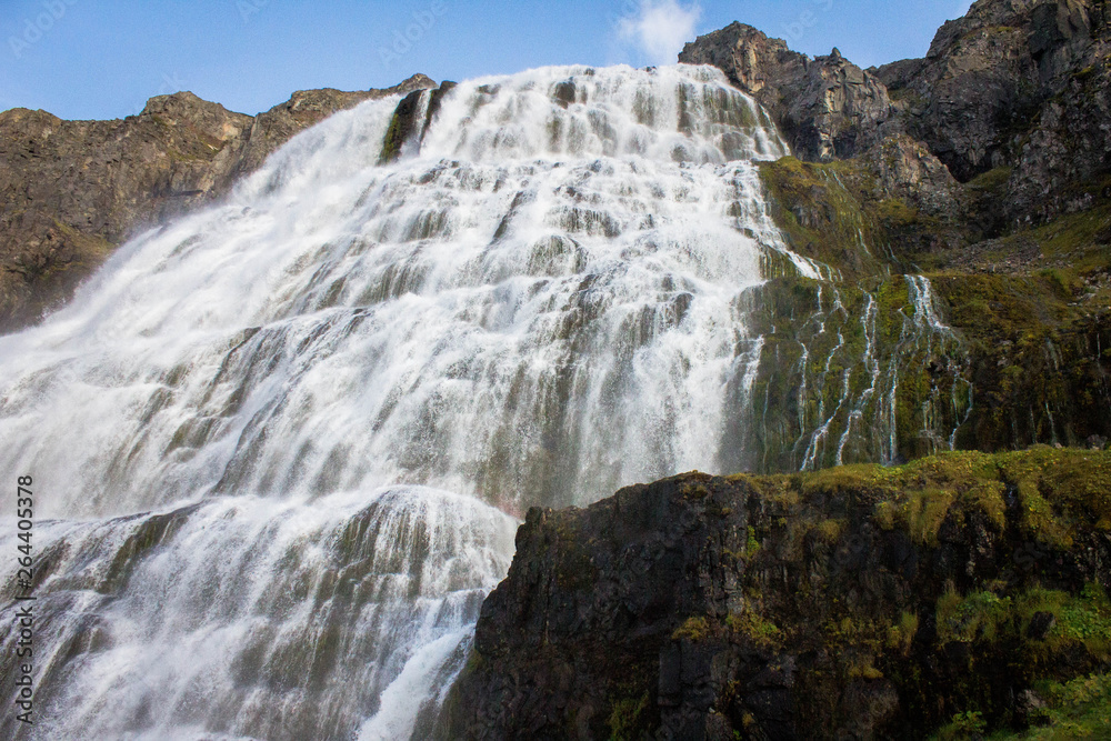 High Dynjandi Falls, waterfall, streams of water breaking from huge rocks in the western fjords in Iceland. Raging tons of water flowing from the mountains. Landscape of wild northern nature.