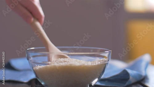 Wallpaper Mural Woman takes Basmati rice with a wooden spoon from a bowl Torontodigital.ca