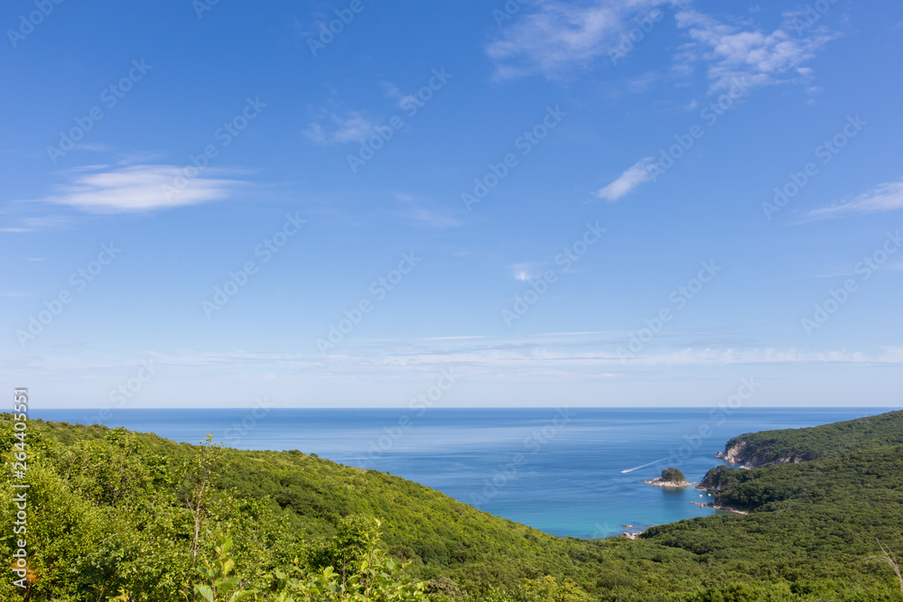 Summer seascape overlooking the green hills, rocky coast and the Japanese Sea