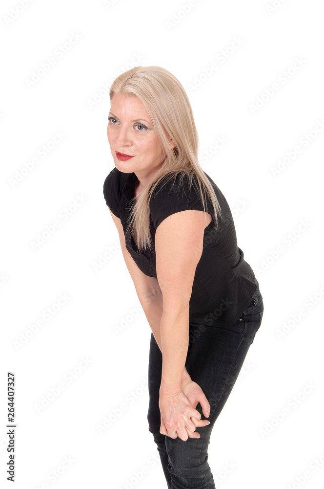 A happy looking blond woman standing in black outfit A happy looking blond woman standing in black outfit