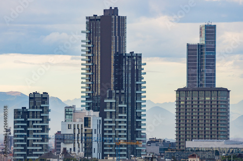 City skyline with skyscrapers of Porta Nuova district in Milan, Italy, Europe. Mountains behind the tall buildings. © Marina