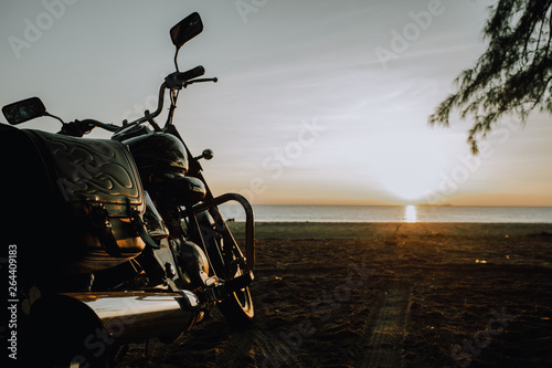 motorbike parked on the beach at the sunrise.