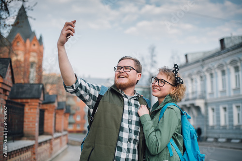A young couple of newlyweds are walking around the big city, taking selfies.