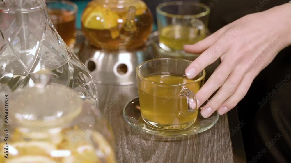 Women's hands taking a cup of tea from the table. Women's hands taking a cup of tea from the table.