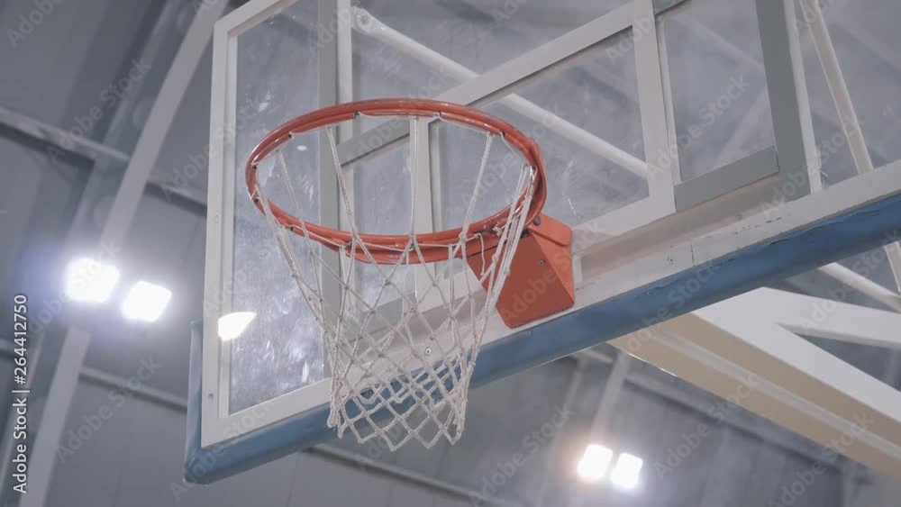 Hands of basketball player throw the ball in the basket, it goes through. Professional basketball game player in action. Concept of sport