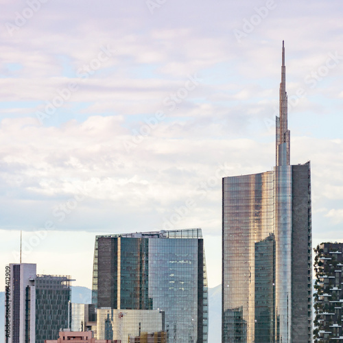 Famous skyscrapers in the business district of Milan, Italy, Europe. Mountains seen behind the city skyline.