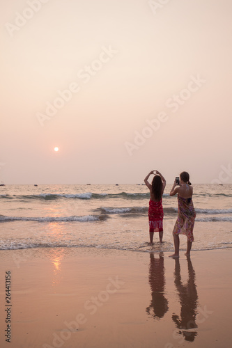 father and son on the beach at sunset