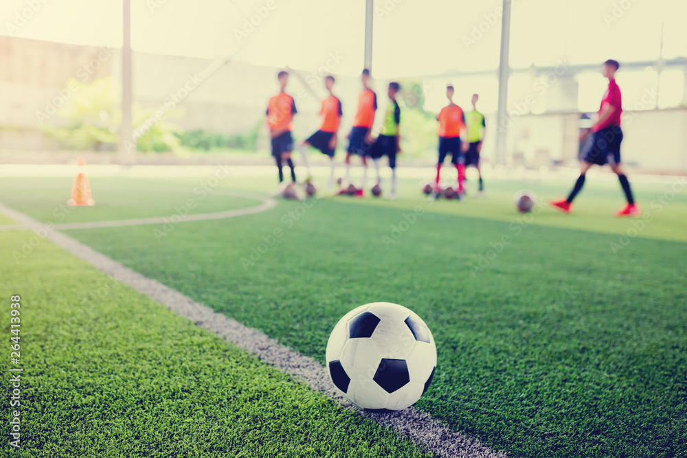 football on green artificial turf with blurry soccer team training