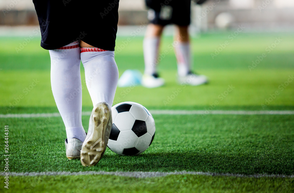 kid soccer player put white sport shoes jogging and control ball go to other players kid soccer player put white sport shoes jogging and control ball go to other players