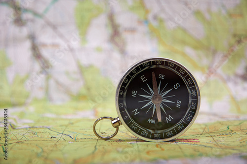 Detailed view of compass and tourist map with defocused background © Forgem