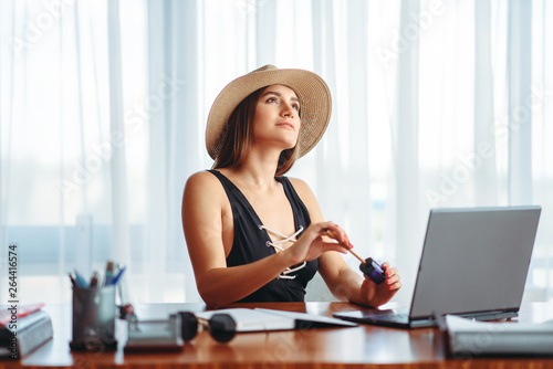 Woman works on laptop, and dreaming about vacation