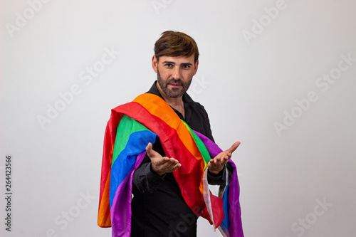 Portrait of handsome young man with gay pride movement LGBT Rainbow flag and brown hair with hate, their back facing the camera and looking at the camera. Isolated on white background.