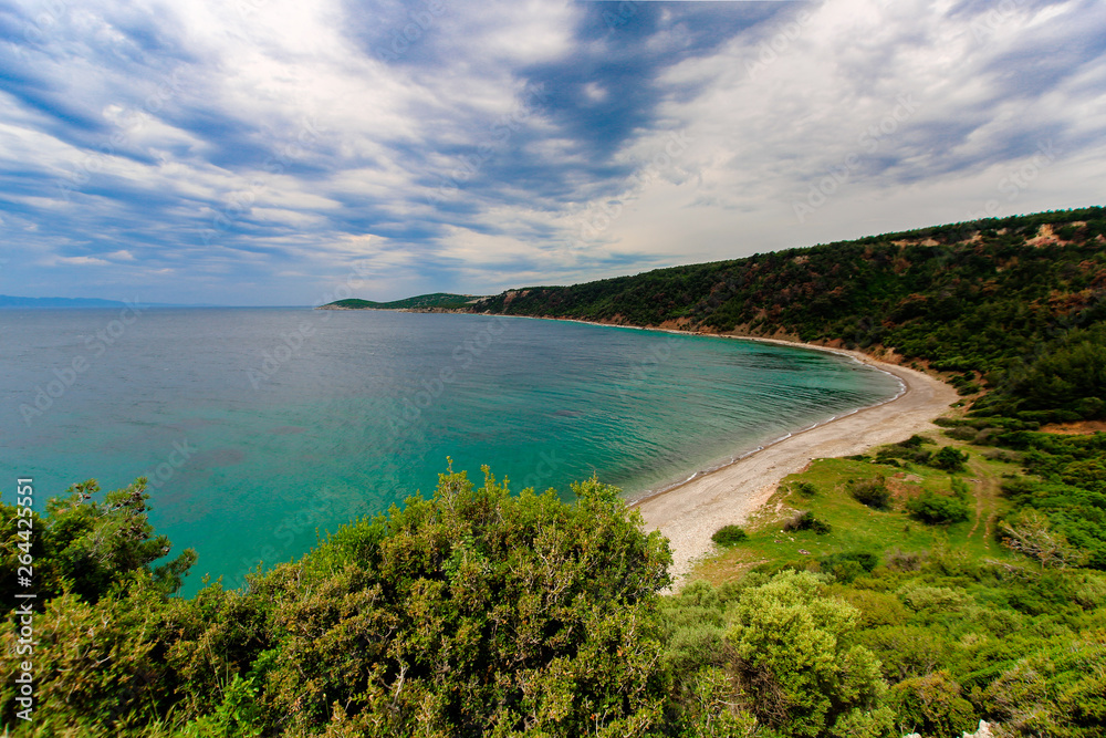 Natural beach in Saros / Turkey. Green grass, trees, cold water and clouds. Camping ground.
