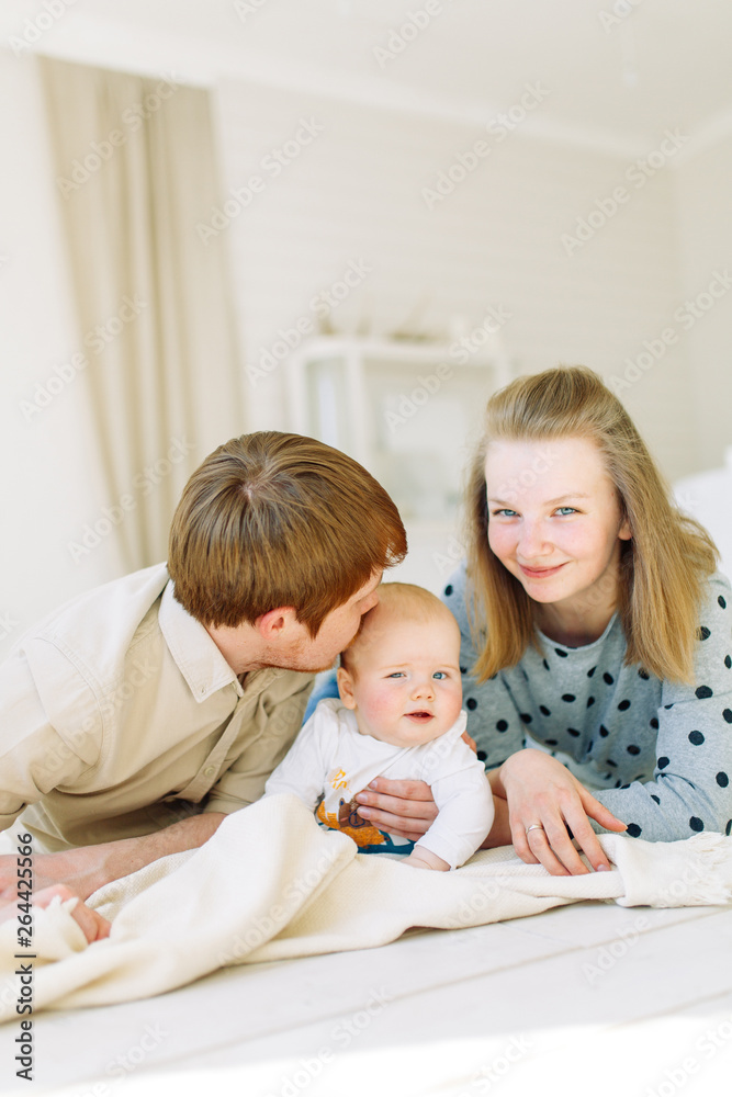 Photo shoot in the Studio, happy parents. Young family on a white background with the child. Photo shoot in the Studio, happy parents. Young family on a white background with the child.