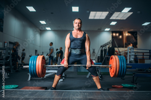 Weightlifter doing exercise with barbell, deadlift